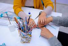 Teacher helping student with craft